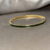 Goudkleurige dunne bangle armband met groene steentjes