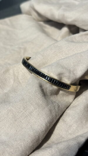 Goudkleurige bangle armband met zwarte steentjes